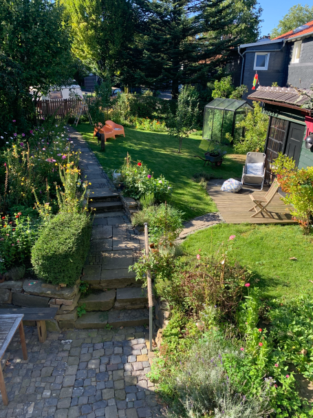 Naturnaher Garten Naturnaher Garten mit Weg aus Naturstein, Holzdeck und großem Staudenbeet